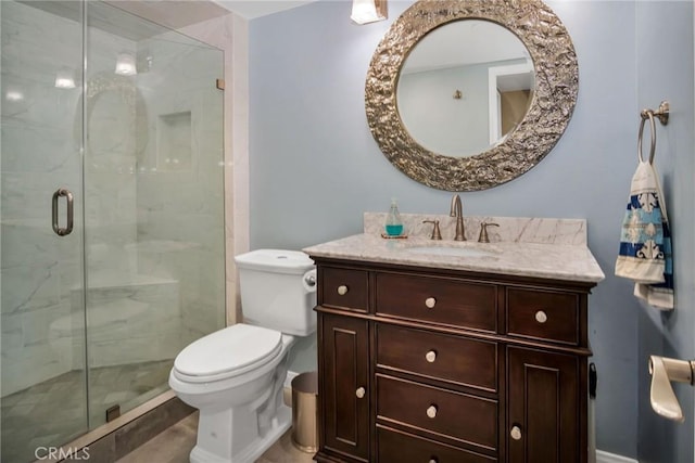 full bathroom featuring a stall shower, vanity, and toilet