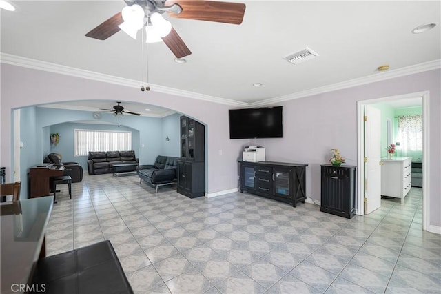 living room with baseboards, visible vents, arched walkways, and crown molding