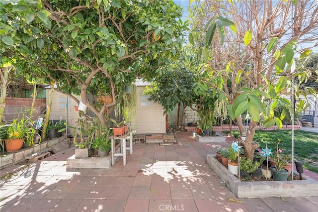 view of patio / terrace with an outdoor structure and fence