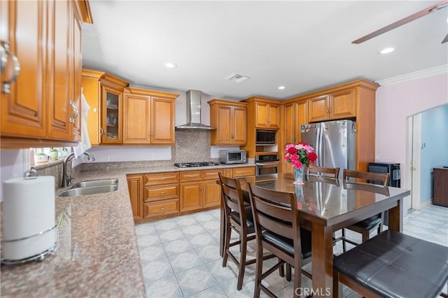 kitchen with recessed lighting, visible vents, appliances with stainless steel finishes, a sink, and wall chimney exhaust hood