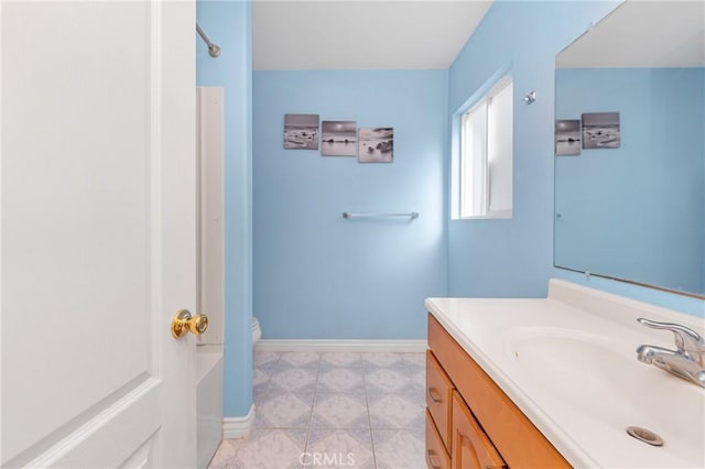 full bathroom featuring a shower, vanity, and baseboards