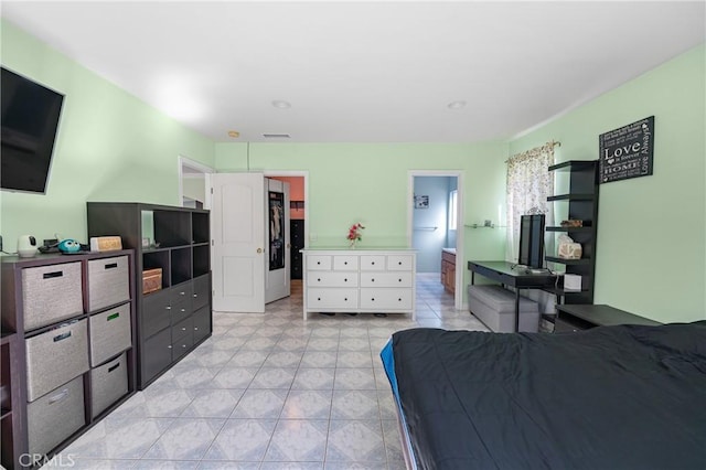 bedroom with light tile patterned flooring and connected bathroom