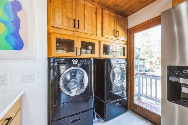 washroom featuring wood ceiling, cabinet space, plenty of natural light, and washer and clothes dryer