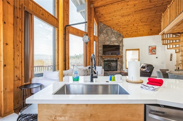 kitchen with wood ceiling, open floor plan, a fireplace, and a sink