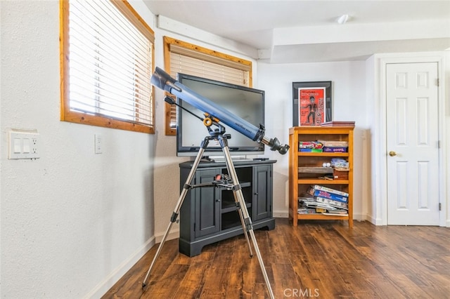 exercise room featuring baseboards and wood finished floors