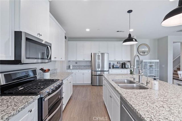 kitchen featuring a sink, visible vents, white cabinets, light wood-style floors, and appliances with stainless steel finishes