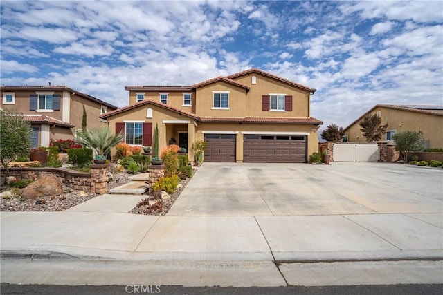 traditional home featuring driveway, a tile roof, an attached garage, fence, and stucco siding