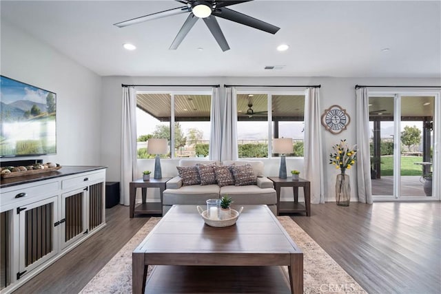 living room with recessed lighting, visible vents, a wealth of natural light, and wood finished floors