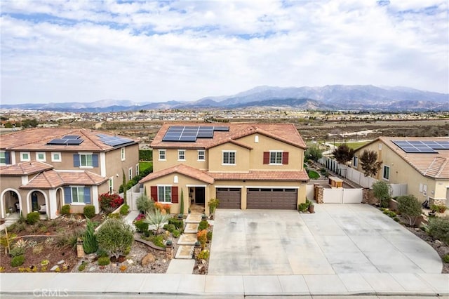 view of front facade featuring a mountain view, fence, a tiled roof, and stucco siding