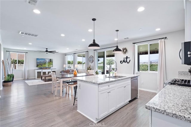 kitchen with white cabinets, visible vents, a sink, and stainless steel dishwasher