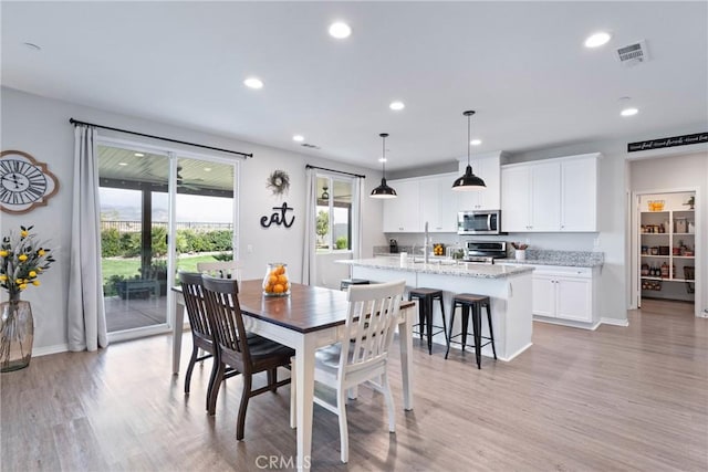 dining area with light wood-style flooring, visible vents, baseboards, and recessed lighting