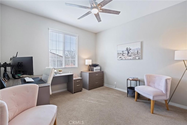 office space with baseboards, a ceiling fan, and light colored carpet