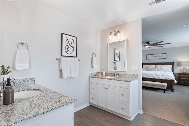 ensuite bathroom featuring two vanities, visible vents, a sink, and ensuite bathroom