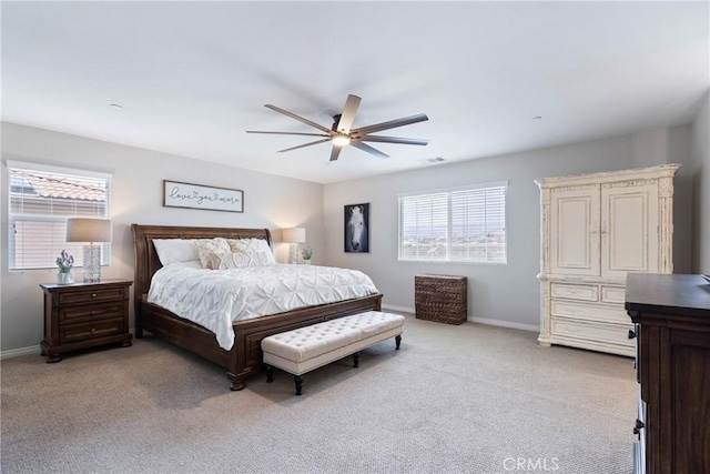 bedroom featuring light carpet, ceiling fan, visible vents, and baseboards