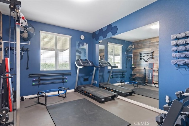 workout room with wood walls and baseboards