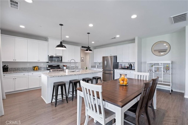 dining area featuring light wood-style floors, visible vents, and recessed lighting