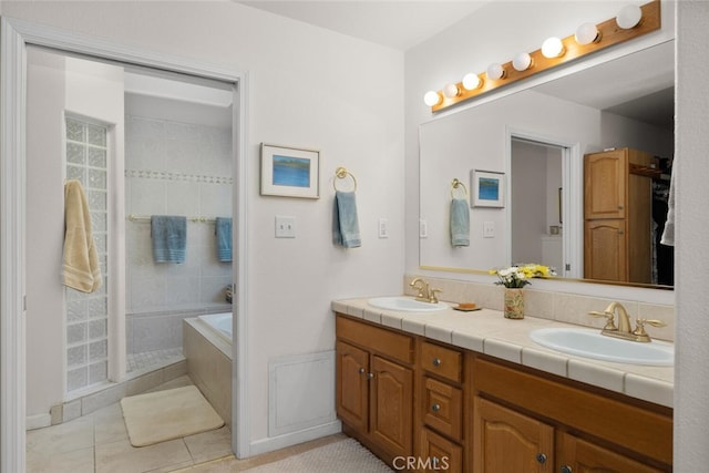 bathroom featuring double vanity, a sink, a bath, and tile patterned floors