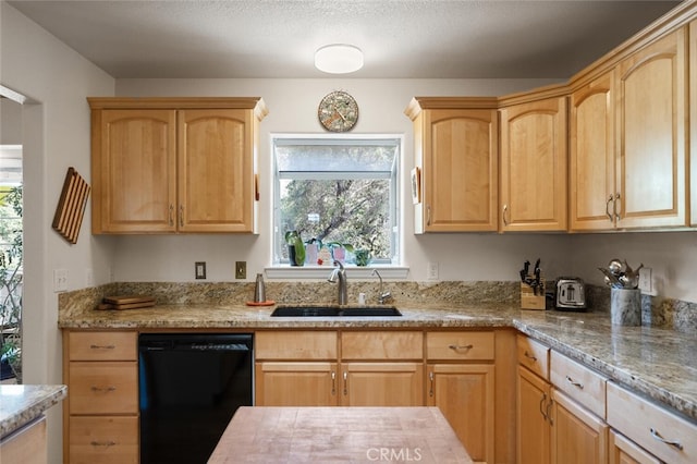 kitchen featuring light brown cabinets, dishwasher, and a sink