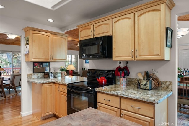 kitchen with a healthy amount of sunlight, black appliances, light brown cabinets, and light wood finished floors