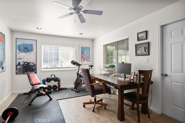 office space with baseboards and a ceiling fan