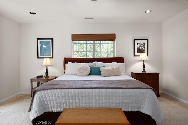 bedroom featuring baseboards, visible vents, and light colored carpet