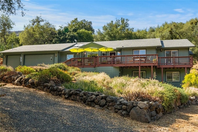 back of house with a wooden deck and an attached garage