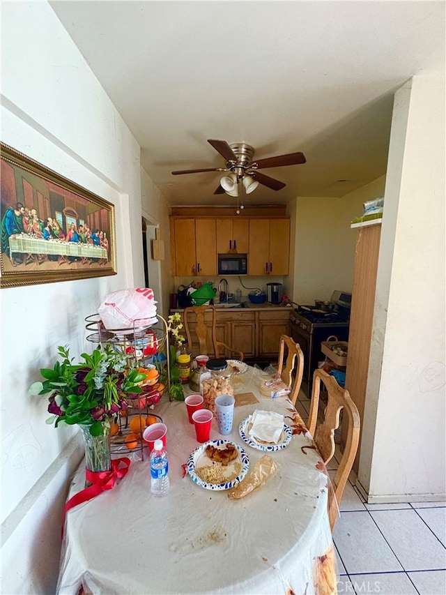 dining area with ceiling fan and light tile patterned flooring