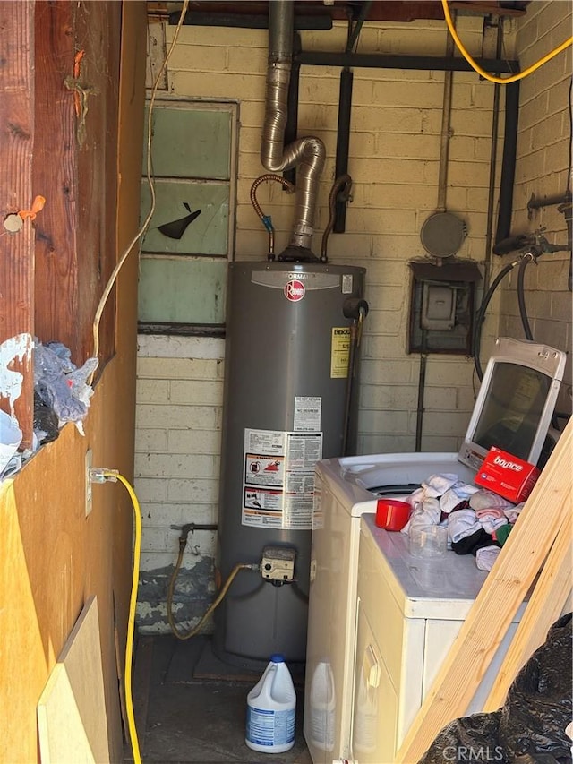 utility room with gas water heater and washer / dryer