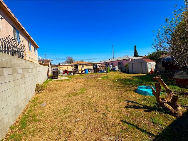 view of yard with an outbuilding, fence, and a storage unit