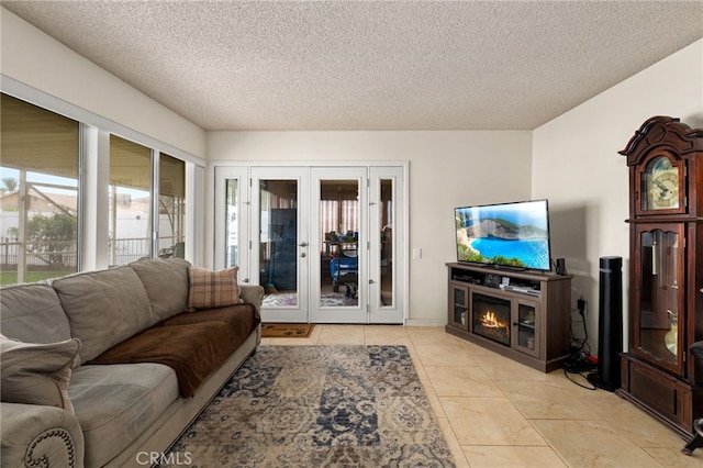 26131 Chambers Ave, Menifee, CA 92586 - living room featuring plenty of natural light, french doors, a textured ceiling, light tile patterned flooring, and a glass covered fireplace