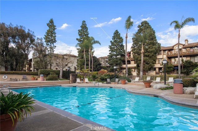 pool with a patio and fence