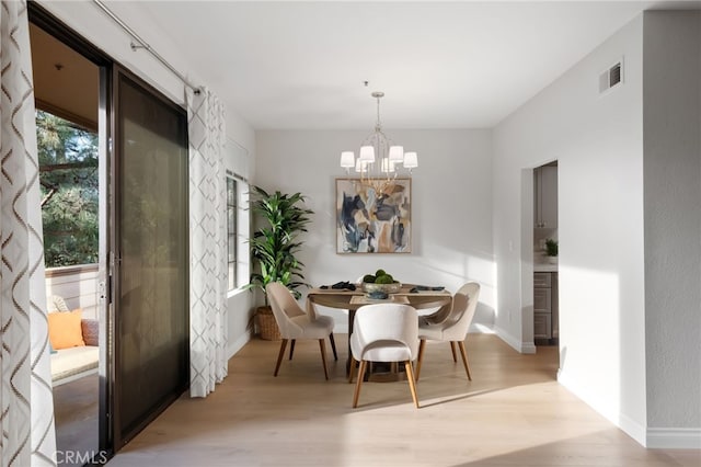 dining area with a notable chandelier, baseboards, visible vents, and light wood-style floors