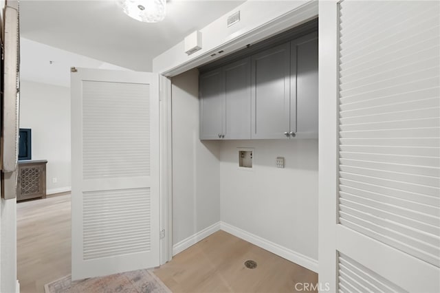 laundry area with washer hookup, cabinet space, light wood-style flooring, and baseboards