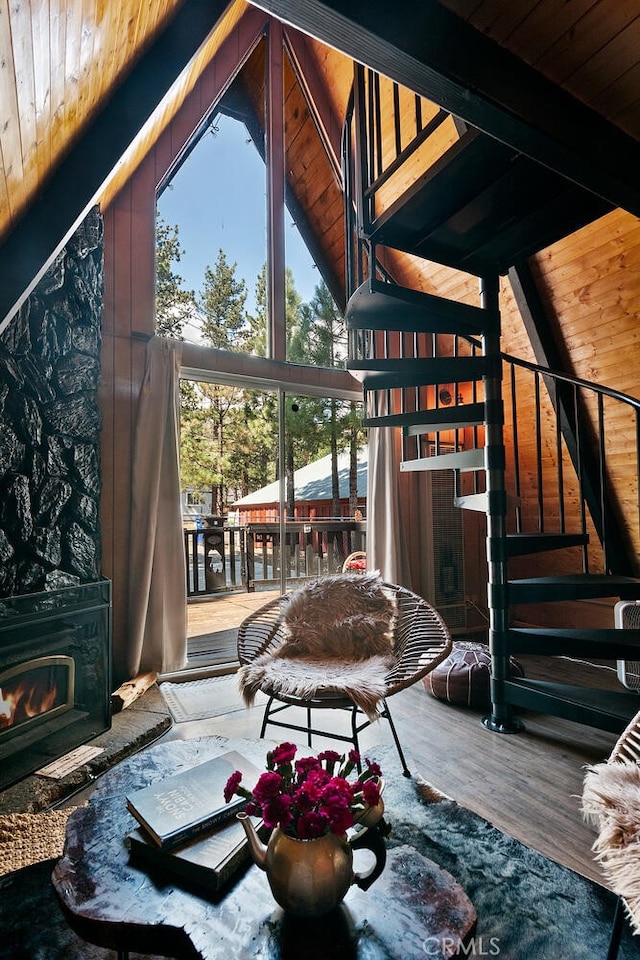 living area featuring beamed ceiling, wood ceiling, stairs, wood finished floors, and high vaulted ceiling