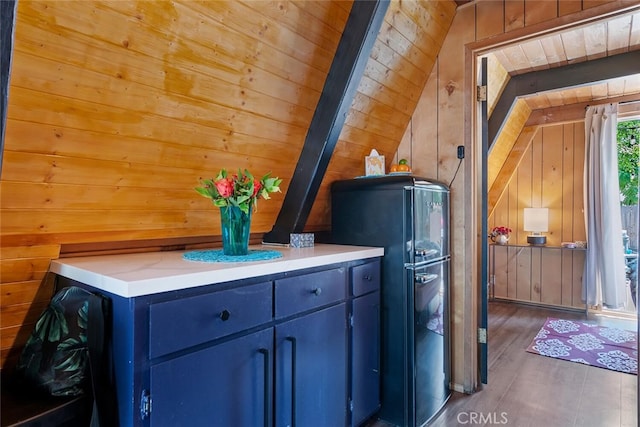 interior space featuring wood walls, freestanding refrigerator, and wood finished floors