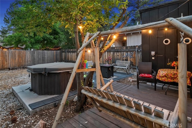 deck with a fenced backyard and a hot tub