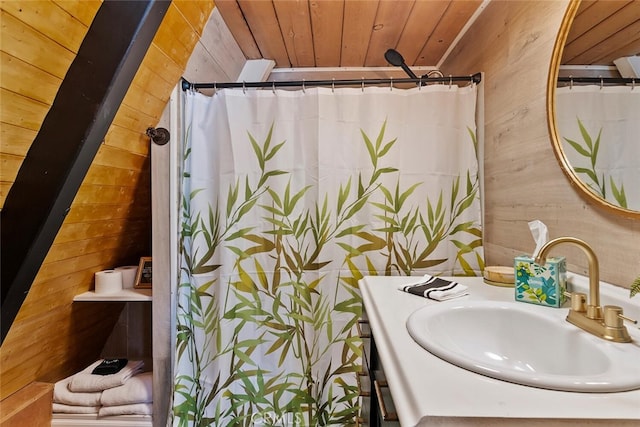 full bath with curtained shower, wooden ceiling, vanity, and wood walls