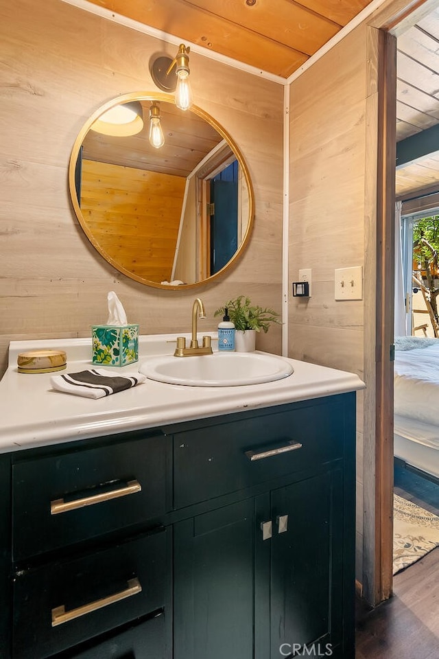 bathroom featuring wood finished floors, wooden walls, wooden ceiling, vanity, and vaulted ceiling