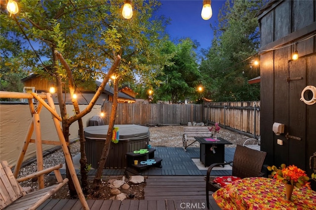 wooden deck featuring a hot tub and a fenced backyard