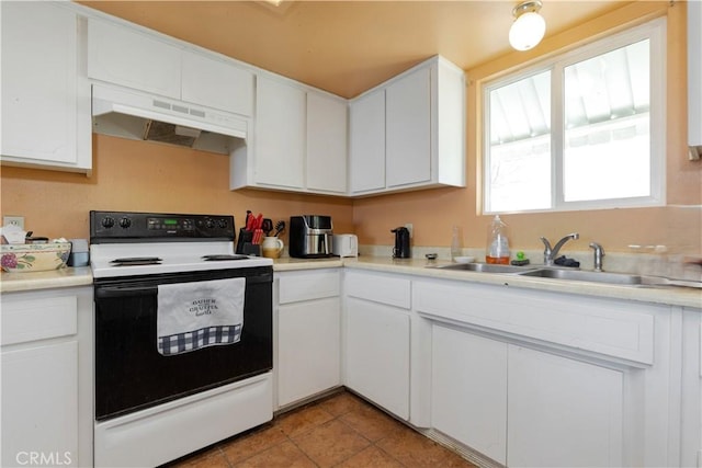 kitchen with under cabinet range hood, light countertops, electric stove, white cabinets, and a sink