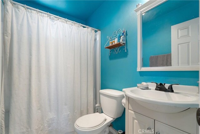 bathroom featuring vanity, toilet, and a shower with curtain