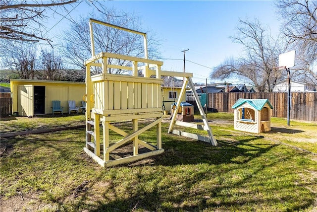 view of play area featuring a yard, an outbuilding, a shed, and fence