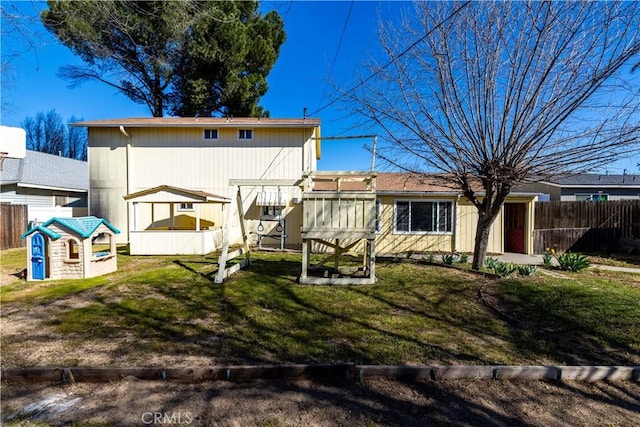 rear view of house with a yard and fence