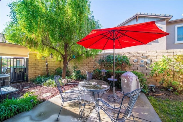 view of patio / terrace featuring cooling unit, outdoor dining area, and fence