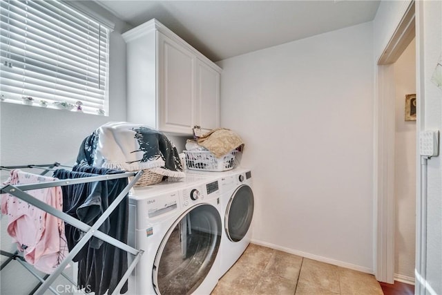 laundry area with cabinet space, baseboards, and washer and clothes dryer