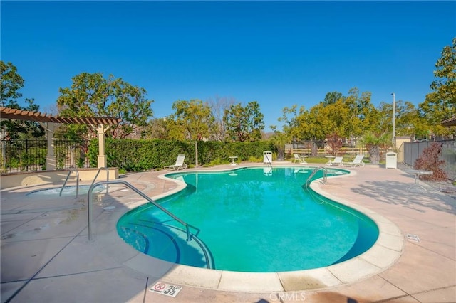 pool with a patio area and fence