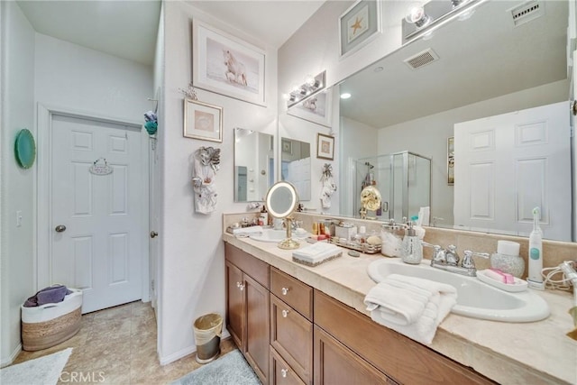 bathroom with a stall shower, a sink, and visible vents