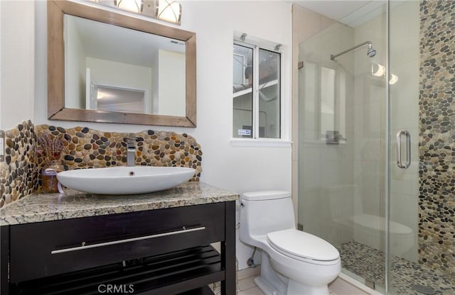 full bath with tasteful backsplash, toilet, vanity, and a stall shower