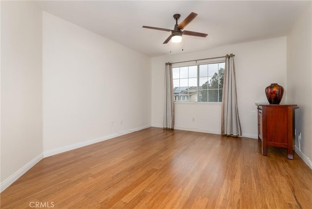 unfurnished room with baseboards, light wood finished floors, and ceiling fan