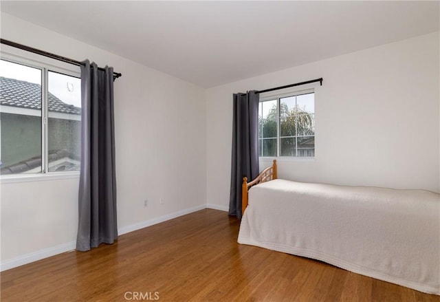 unfurnished bedroom featuring baseboards and wood finished floors